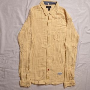 A yellow long-sleeved button-downed shirt